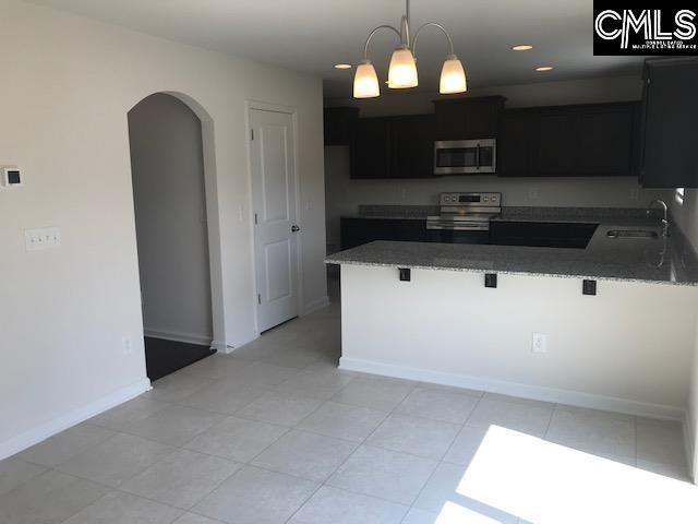 730 Lansford Bay Dr, West Columbia, SC 29172 - kitchen with a kitchen breakfast bar, appliances with stainless steel finishes, arched walkways, a sink, and dark cabinets