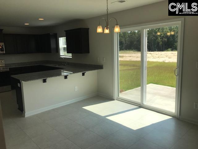 730 Lansford Bay Dr, West Columbia, SC 29172 - kitchen with a peninsula, baseboards, a kitchen bar, a sink, and hanging light fixtures