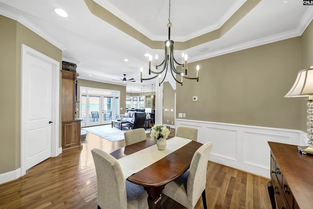 305 Marina Ct, Lexington, SC 29072 - dining room featuring a raised ceiling, a decorative wall, ornamental molding, a wainscoted wall, and dark wood-style floors