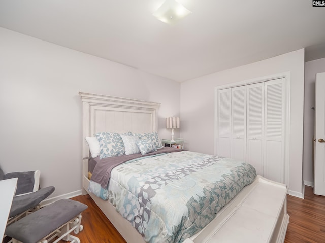 bedroom with baseboards, wood finished floors, and a closet