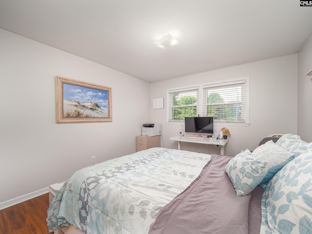 bedroom with baseboards and wood finished floors