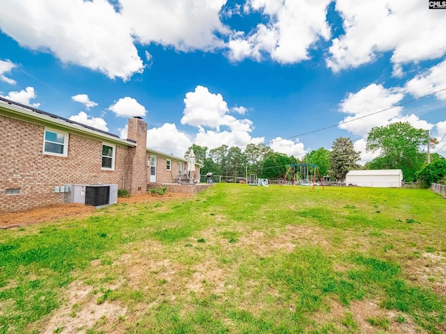 view of yard featuring a playground and central AC