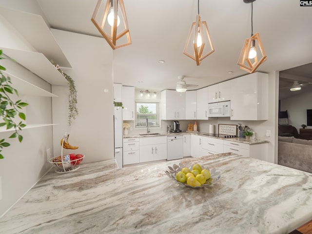 kitchen featuring ceiling fan, hanging light fixtures, a sink, white appliances, and white cabinetry