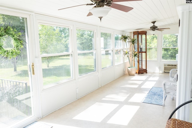 unfurnished sunroom featuring a wall mounted air conditioner and a wealth of natural light