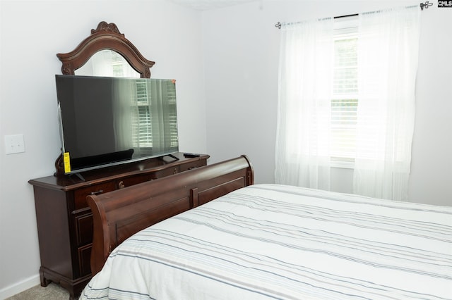 bedroom featuring baseboards and carpet