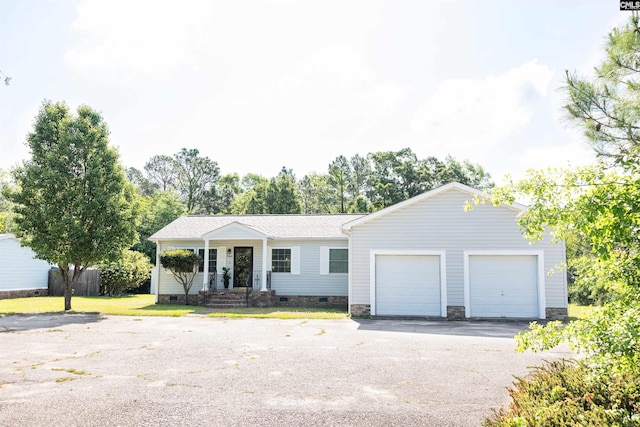 single story home featuring aphalt driveway, a front yard, crawl space, and covered porch