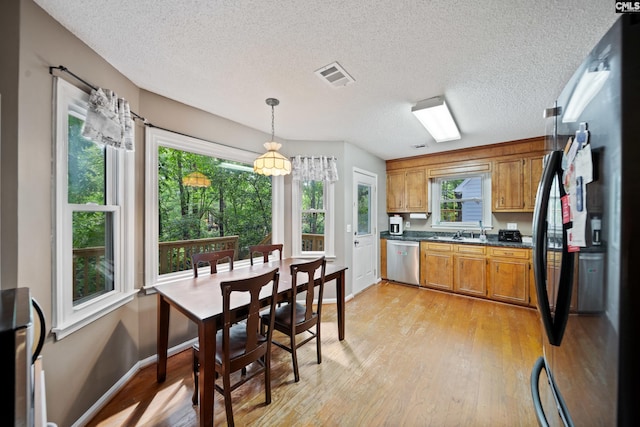 120 Coventry Lake Dr, Lexington, SC 29072 - kitchen featuring freestanding refrigerator, dishwasher, dark countertops, brown cabinets, and light wood-type flooring