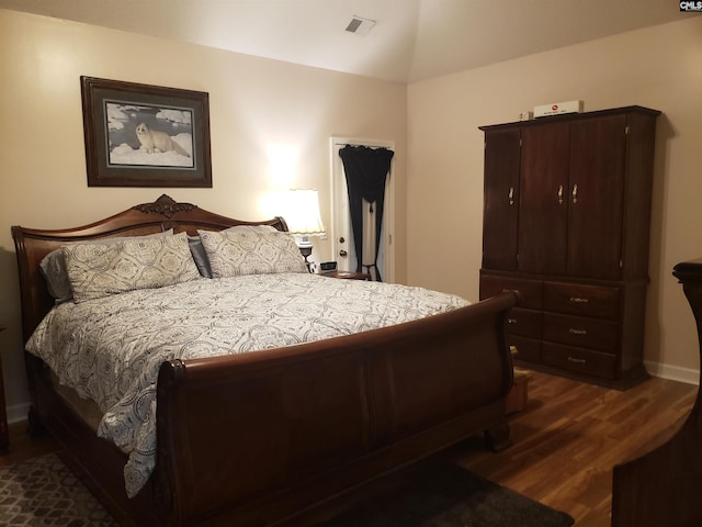 bedroom with dark wood-type flooring, baseboards, visible vents, and vaulted ceiling