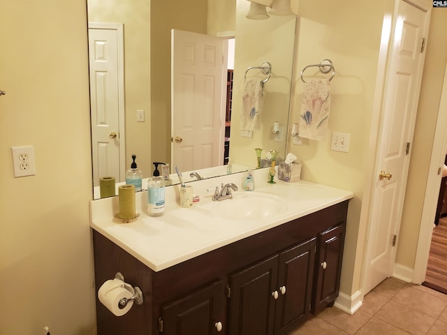 bathroom with vanity, baseboards, and tile patterned floors