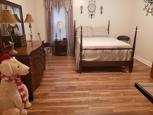 bedroom with baseboards and light wood finished floors