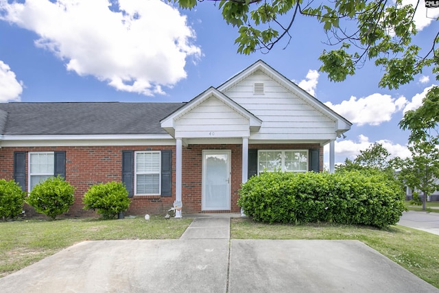 view of front of home featuring a front lawn and brick siding