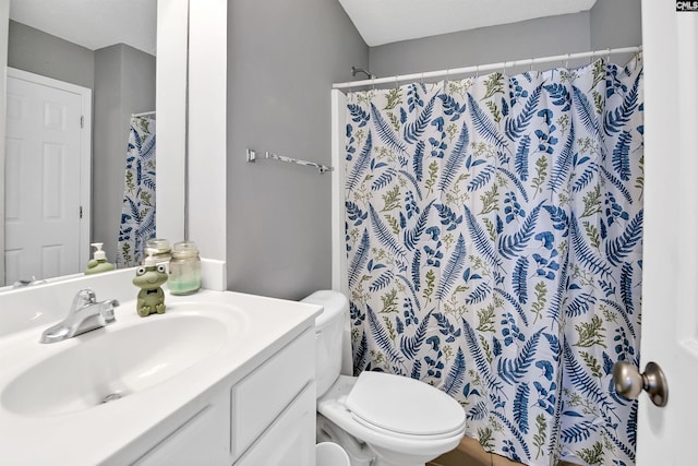 bathroom with vanity, curtained shower, and toilet