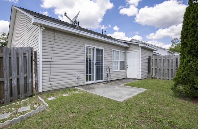 rear view of property with a lawn, fence, and a patio area