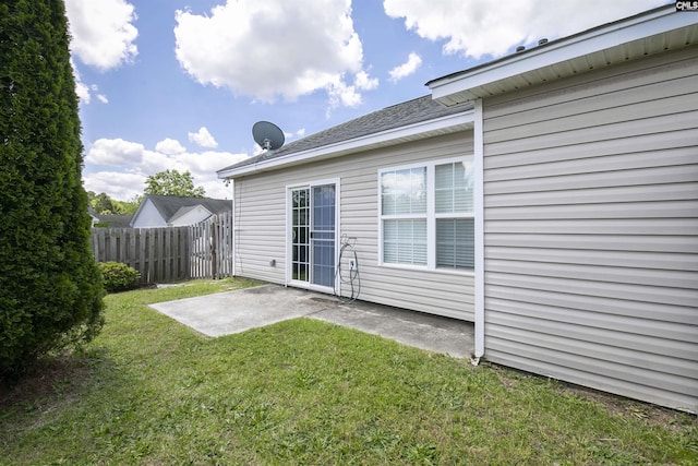 back of property with a lawn, a patio area, and fence