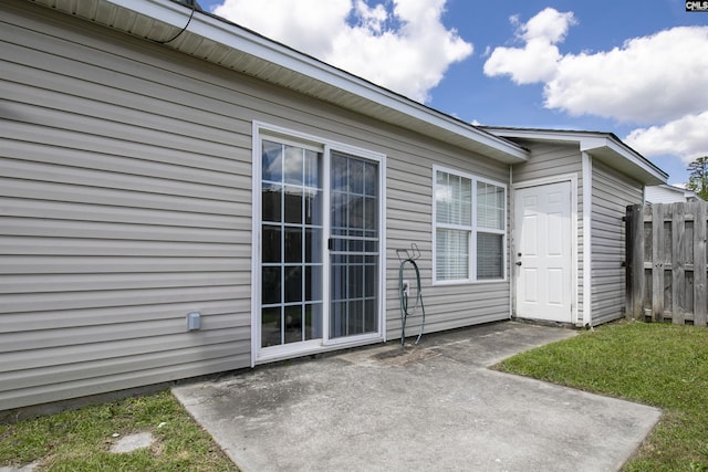 entrance to property featuring a patio and fence