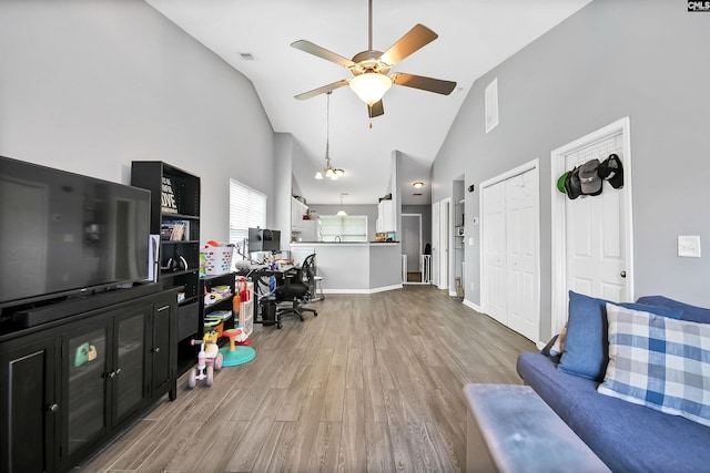 living area with high vaulted ceiling, ceiling fan, wood finished floors, and visible vents