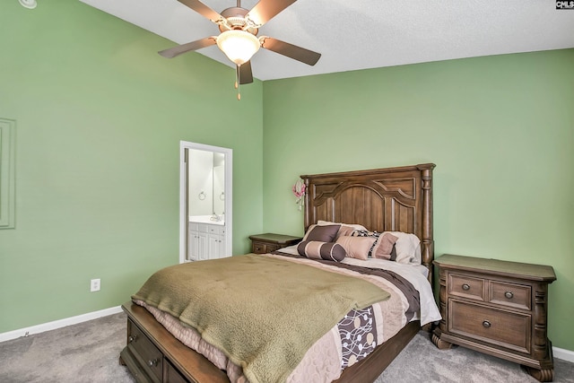 carpeted bedroom with baseboards, a high ceiling, a ceiling fan, and ensuite bath
