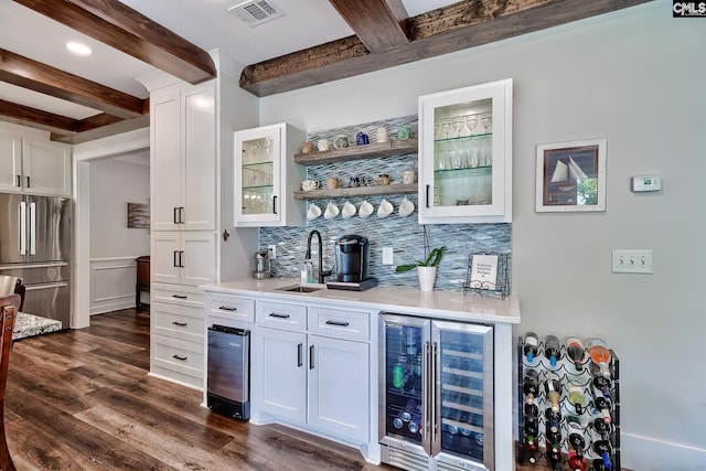 bar featuring visible vents, a sink, indoor wet bar, freestanding refrigerator, and beverage cooler