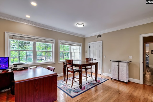 office featuring visible vents, ornamental molding, baseboards, and light wood-type flooring
