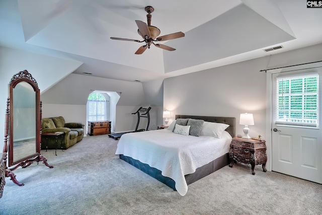 bedroom with ceiling fan, visible vents, a raised ceiling, lofted ceiling, and carpet