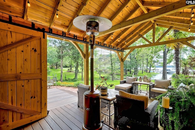 wooden terrace featuring a water view, a gazebo, and an outdoor living space