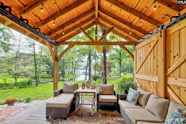 exterior space with a water view, beamed ceiling, and a barn door