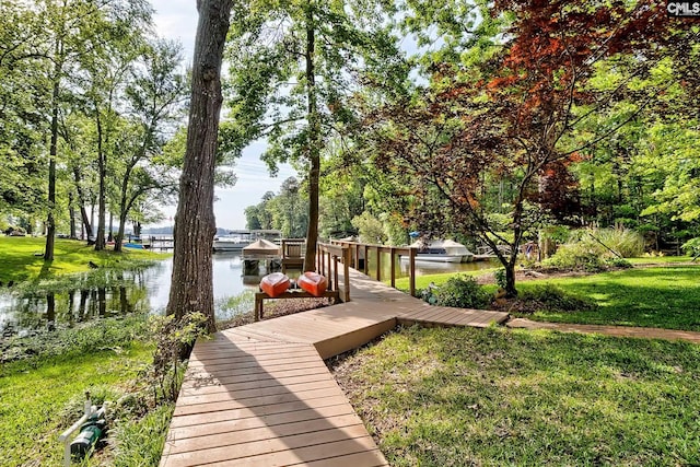 dock area with a lawn and a water view