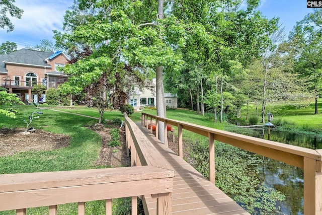 view of property's community with a water view and a yard