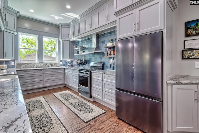 215 Greenbrier Mossydale Rd, Winnsboro, SC 29180 - kitchen with wall chimney range hood, appliances with stainless steel finishes, decorative backsplash, and wood finished floors