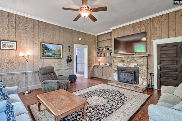 215 Greenbrier Mossydale Rd, Winnsboro, SC 29180 - living room featuring ceiling fan, a fireplace, wood walls, wood finished floors, and ornamental molding