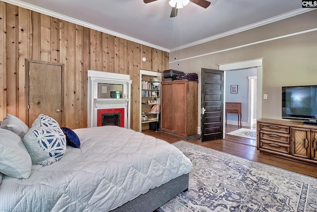 215 Greenbrier Mossydale Rd, Winnsboro, SC 29180 - bedroom featuring a ceiling fan, a fireplace, wood walls, wood finished floors, and ornamental molding