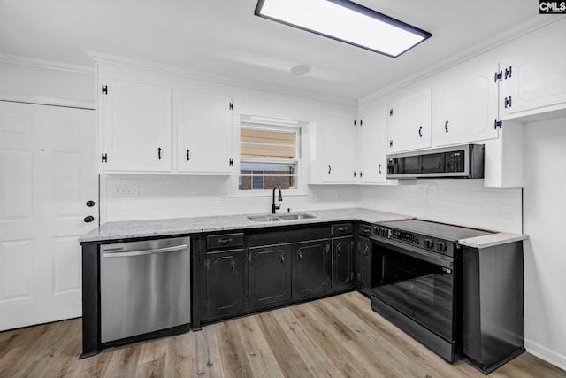 kitchen with white cabinets, stainless steel appliances, dark cabinets, and a sink