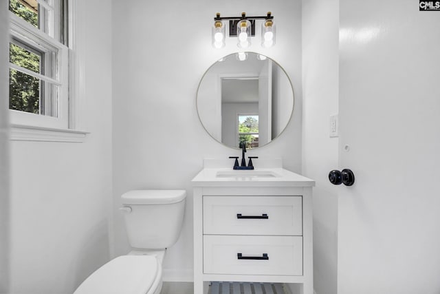 bathroom featuring vanity, plenty of natural light, and toilet