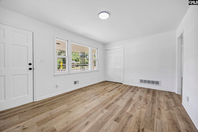interior space with baseboards, visible vents, and wood finished floors