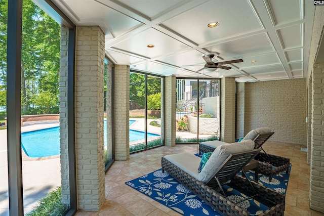 sunroom / solarium with a ceiling fan and coffered ceiling