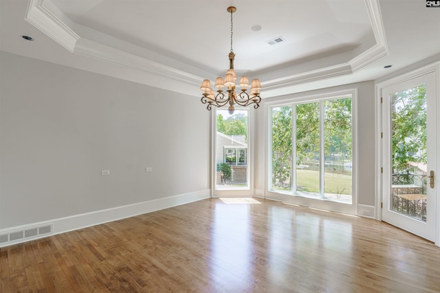 spare room with a notable chandelier, a tray ceiling, and visible vents
