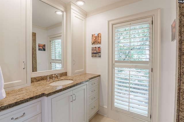 bathroom with a healthy amount of sunlight, vanity, and crown molding