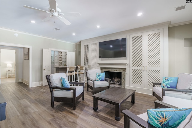 living room with ornamental molding, ceiling fan, and visible vents