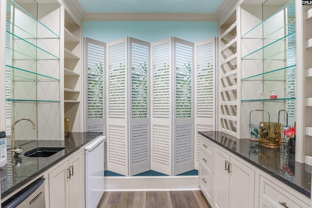 bar with crown molding, a sink, wood finished floors, and dishwasher