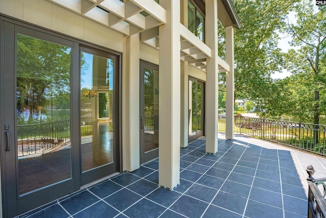 view of patio / terrace featuring a water view and fence