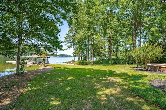 view of yard with a water view and a dock