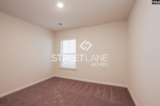 unfurnished room with visible vents, baseboards, and dark carpet