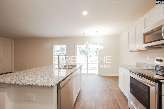 kitchen with white cabinetry, light wood-style floors, stainless steel appliances, and a sink