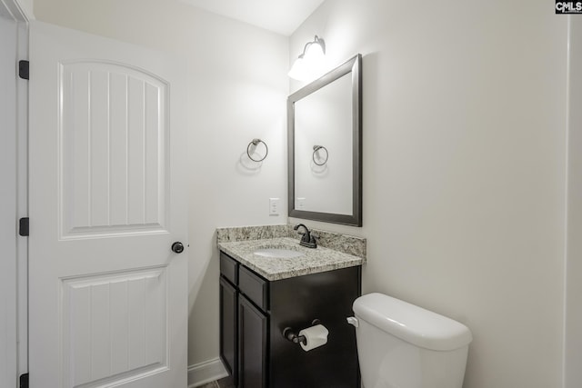 half bath featuring toilet and vanity