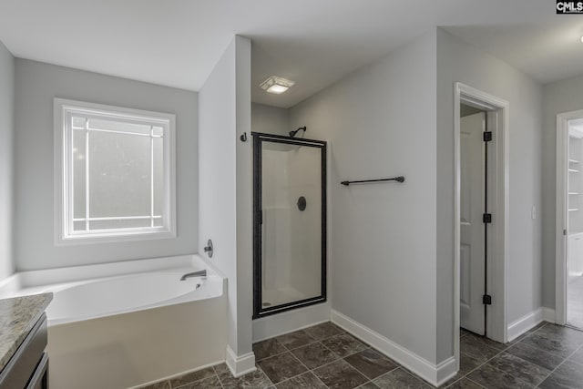 bathroom featuring vanity, baseboards, a stall shower, and a bath
