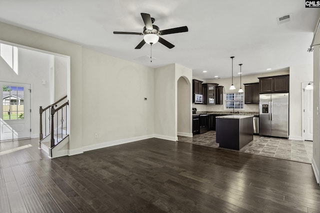 unfurnished living room with a ceiling fan, baseboards, visible vents, and wood finished floors