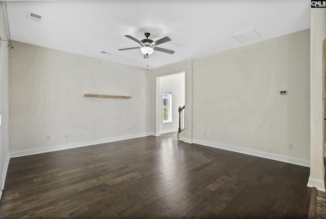 unfurnished room featuring baseboards, a ceiling fan, wood finished floors, and visible vents