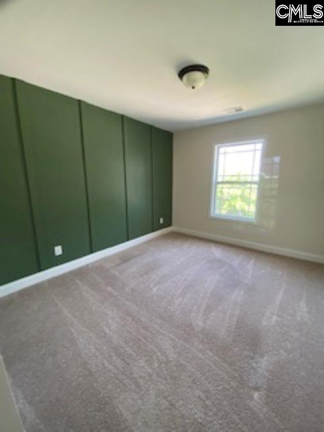 carpeted empty room featuring baseboards