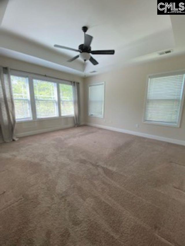 carpeted empty room with baseboards and a ceiling fan