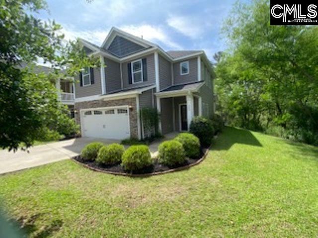craftsman inspired home featuring a front lawn, driveway, and an attached garage